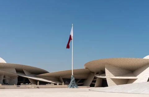 Wide angle of Qatari flag at National Museum of Qatar with copy space Stock Photos