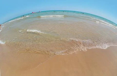 Wide angle sandy beach on the Mediterranean Sea, blue sky and sea, the fish-eye Stock Photos