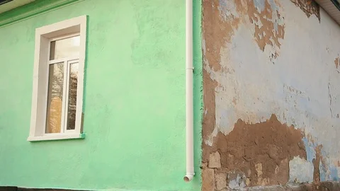 Wide angle of semi-constructed green building. One renovated and one broken Видео 100037702