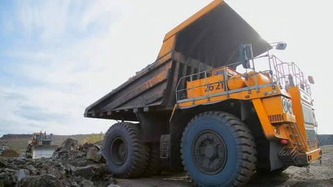Wide angle shoot Yellow dump truck unloads rocks and gravel Stockbeeldmateriaal 122074459
