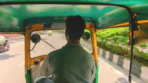 Wide angle shot of an auto rikshaw or tuk tuk driver on roads of Delhi Stock Footage 247888640