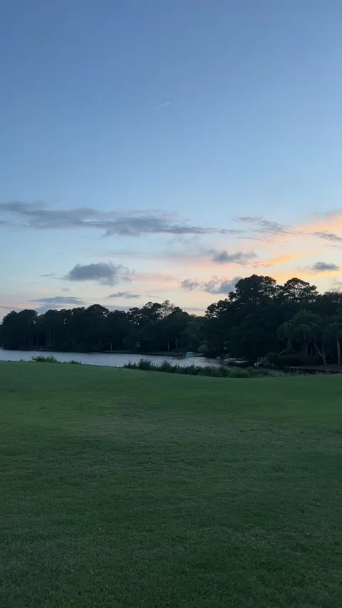 Wide angle shot of beach golf course at sunset with pond In background Stock Footage 196818980