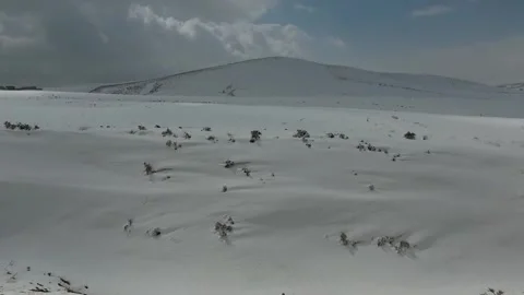 A wide angle shot captures a lone snow covered hill rising, stock footage. Stock Footage 304867127