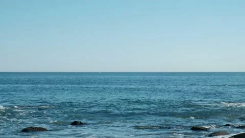 Wide angle shot of a far off whale jumping out of the water Stock Footage 136682642