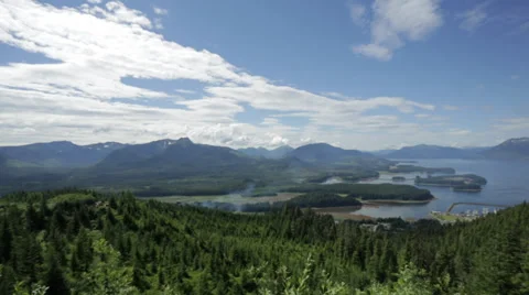A wide angle shot of green mountains and a bay in Icy Straight, AK Stock Footage 36309643