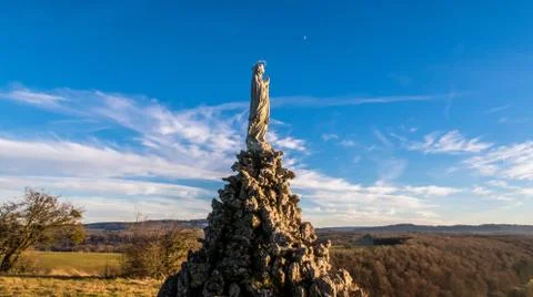 Wide angle shot from low angle of view of a Virgin Mary statue with moon and  Stock Photos