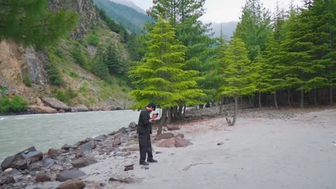 Wide angle shot of river flowing besides Pine tree forest  Stock Footage 341317785