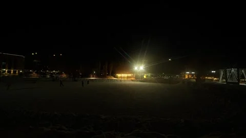 Wide angle shot of a snow covered city park and public ice rink at night. Stock Footage 328418399