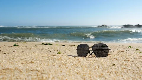 Wide angle shot of sunglasses on sandy beach in summer Stock Footage 108642675