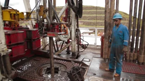 Wide Angle Shot of two oil and gas workers at an oil well Stock Footage 45236340