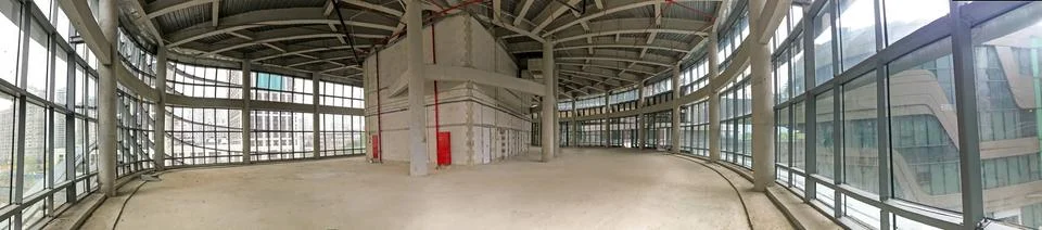 Wide-angle shot of an under-construction building with expansive glass walls  库存照片