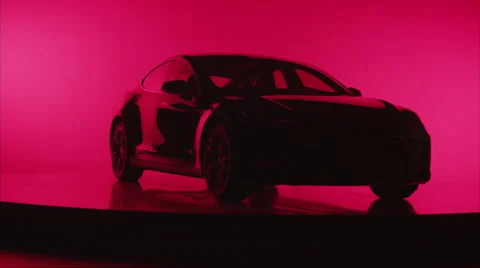 Wide angle silhouette of a car rotating on turntable against red background Stock Footage 64912344