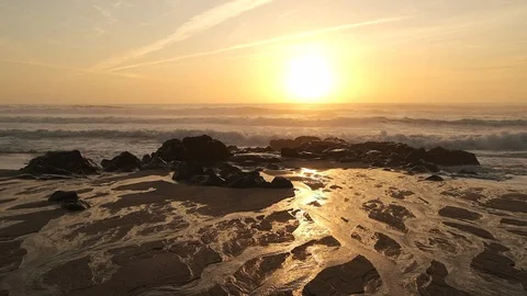 Wide angle, slow motion view over beach at sunset. Pan left over wet sand. Stock Footage 116756294