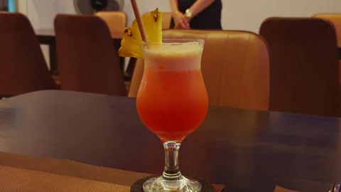 Wide Angle Slow Motion View of Tropical Cocktail with Pineapple Slice on Dark Wo 库存影片 323676852