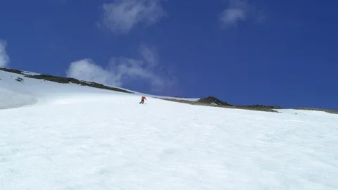 Wide angle Slowmo of pro skier freeriding with blue sky in background, Iceland Stock Footage 124228607