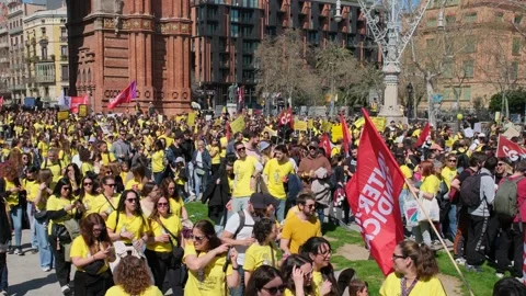 Wide angle of thousands of teachers wearing yellow shirts gathered at Barcelona Stock Footage 331169757