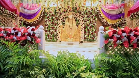 A wide-angle, tilted view of the Sai Baba or Sai Ram idol surrounded by flo.. Video stock 328011409