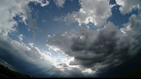 Wide-angle timelapse of stormy clouds rmoving across the sky as bright sun rays Stock Footage 329239237