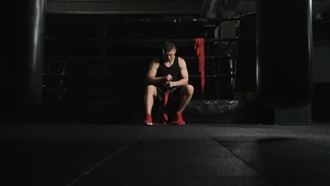 Wide angle. Track in. athletic body guy boxer of European appearance putting on Stock Footage 110724428