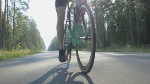 Wide angle tracking shot of a cyclist riding a bike in nature Stock Footage 74560627
