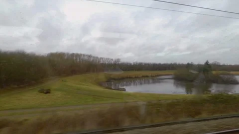 Wide Angle of Train Passes a Pond Stock Footage 113990590