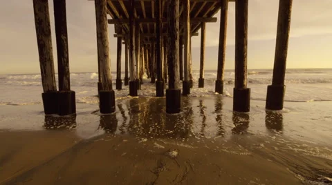 Wide angle under beach pier as waves roll in Vidéo 52678254