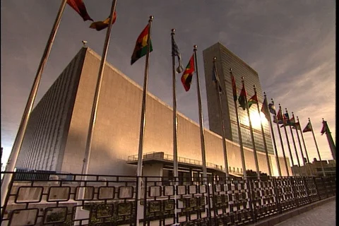 Wide angle of the United Nations building with row of flagpoles and flags. Video stock 86753008
