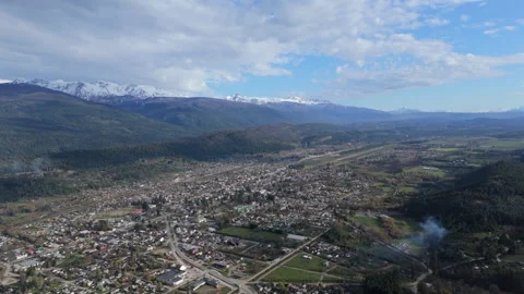 Wide angle upward tilting shot over El Bolsón town and mountain range in Stock Footage 296741471