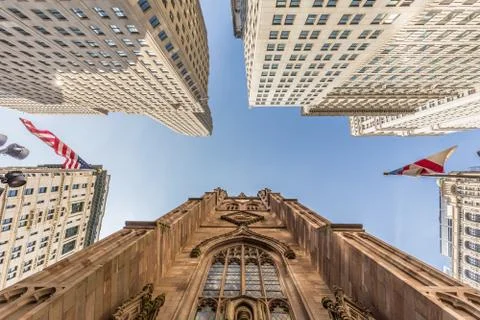 Wide angle upward view of Trinity Church at Broadway and Wall Street with Stock Photos