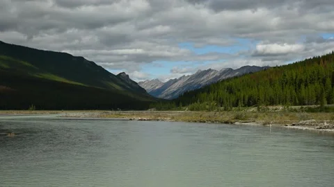 Wide angle view of a blue-grey river flowing through a broad river valley.  Stock Footage 138817345