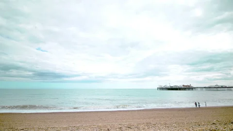 Wide-angle view of Brighton Pier and people relaxing on the beach. Stock Footage 134607806