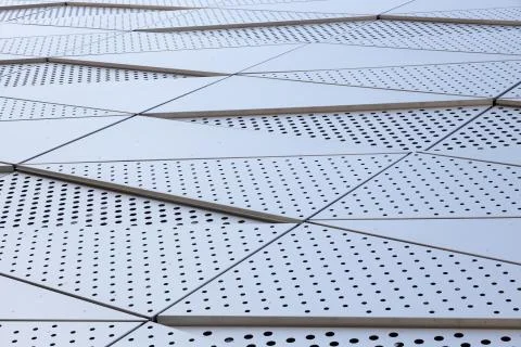 Wide angle view of building wall with triangular pattern and round holes Stock Photos