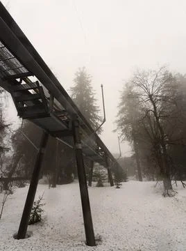 Wide angle view of cable car bridge in the forest snow Foto stock