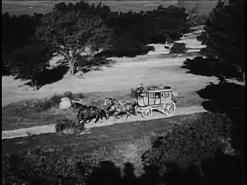 Wide angle view of coachman driving stagecoach on country road, 1940s Stock Footage 61766889