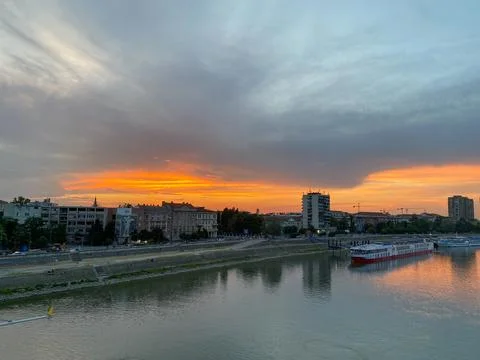 Wide-angle view of a dramatic orange sunset over the Danube River Stock Photos