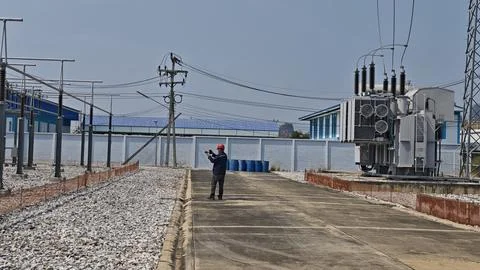 Wide angle view of electrical engineer worker with red helmet inspecting. Stock Photos