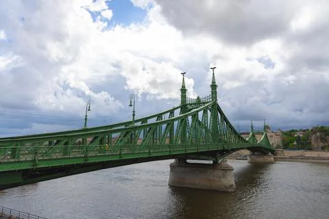 Wide-angle view of an elegant green steel bridge spanning a river Foto stock