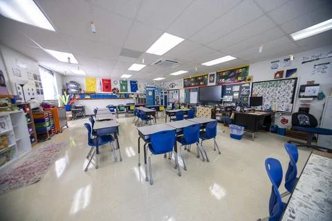 Wide angle view of empty elementary school classroom with interactive whiteboard Stock Photos