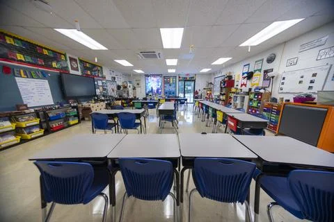 Wide angle view of empty elementary school classroom with interactive whiteboard Stock Photos