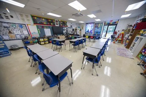 Wide angle view of empty elementary school classroom with interactive whiteboard Stock Photos