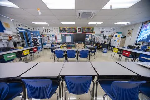 Wide angle view of empty elementary school classroom with interactive whiteboard Stock Photos