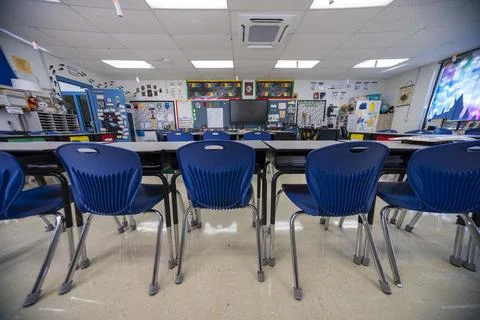 Wide angle view of empty elementary school classroom with interactive whiteboard Stock Photos