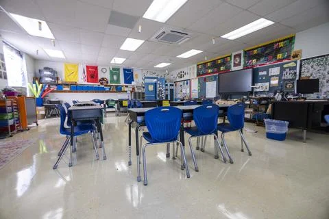 Wide angle view of empty elementary school classroom with interactive whiteboard Stock Photos