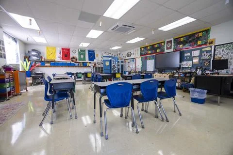 Wide angle view of empty elementary school classroom with interactive whiteboard Stock Photos