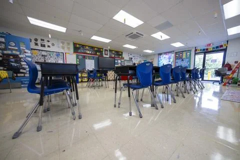 Wide angle view of empty elementary school classroom with interactive whiteboard Stock Photos