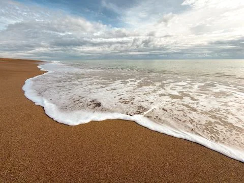 Wide-angle view of gentle surf meeting expansive sandy Lara Beach, Antalya Stock Photos
