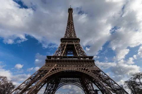 Wide angle view of iconic Eiffel tower with dramatic cloudy blue sky in 写真素材