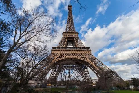 Wide angle view of iconic Eiffel tower with dramatic cloudy blue sky Stock Photos