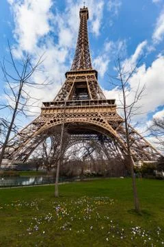 Wide angle view of iconic Eiffel tower with dramatic cloudy blue sky Stock Photos