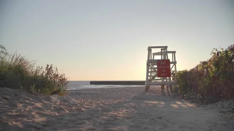 Wide Angle View of Lifeguard Tower and Sandy Beach Path at Golden Hour by the Se Stock Footage 326292593